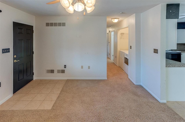 interior space with light colored carpet, visible vents, and light tile patterned floors