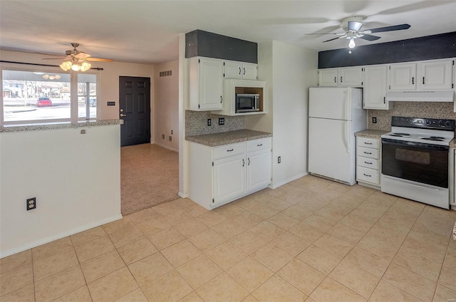 kitchen featuring visible vents, decorative backsplash, electric range oven, stainless steel microwave, and freestanding refrigerator