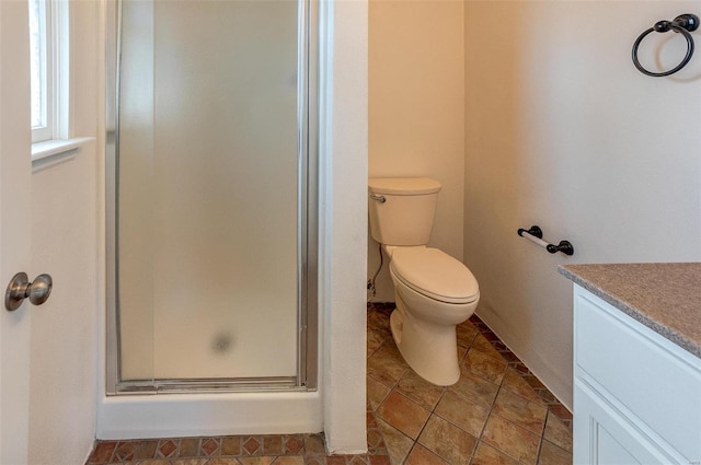 bathroom featuring toilet, a shower stall, and vanity