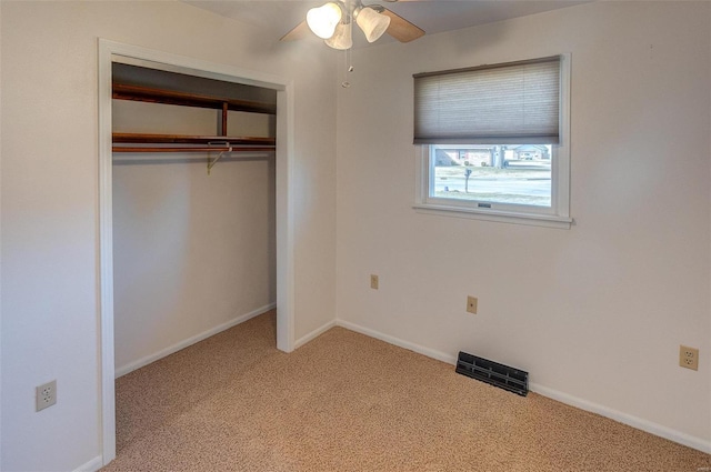 unfurnished bedroom featuring ceiling fan, a closet, carpet flooring, and baseboards