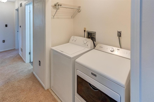 washroom featuring washing machine and dryer, light colored carpet, laundry area, visible vents, and baseboards