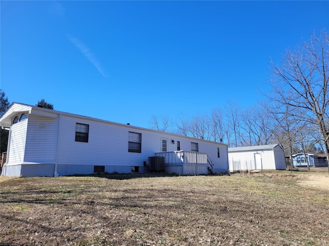 back of property featuring a deck, central AC, and a yard