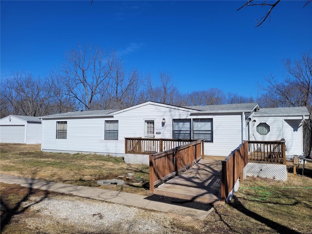 manufactured / mobile home featuring a garage, an outdoor structure, and a wooden deck