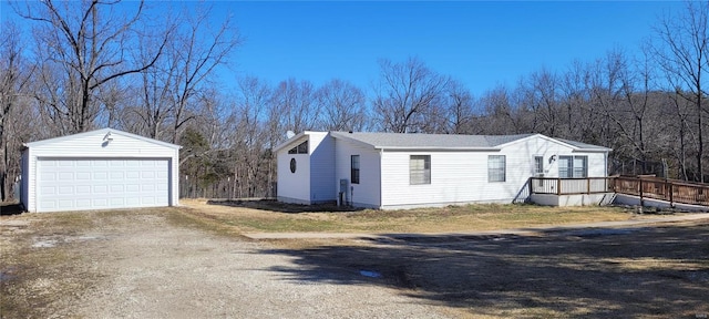 exterior space with an outbuilding, a wooden deck, and a garage