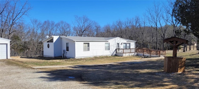 view of front of home featuring a deck, driveway, and a garage