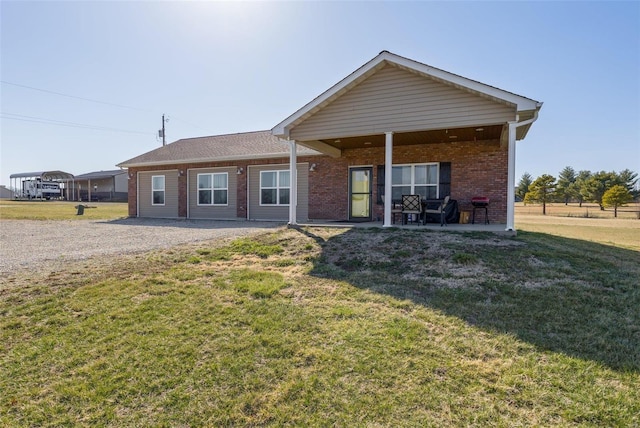 back of property with brick siding and a lawn