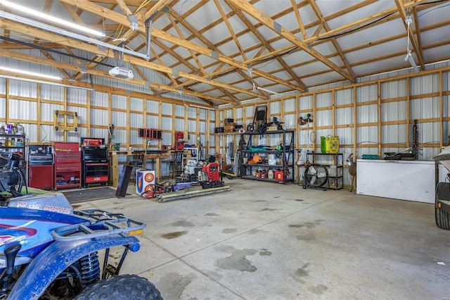 garage featuring metal wall, a workshop area, and a garage door opener