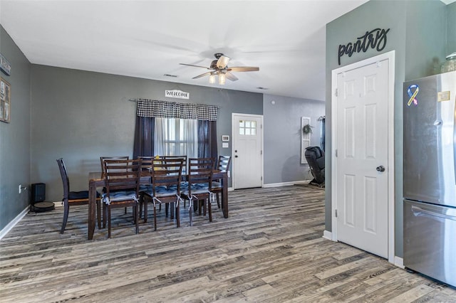 dining space featuring visible vents, wood finished floors, baseboards, and ceiling fan