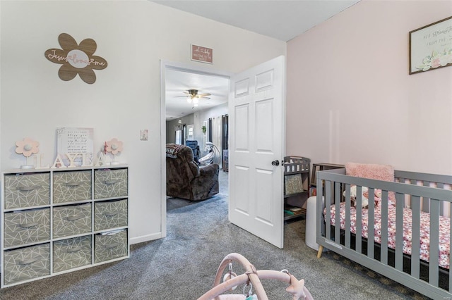 carpeted bedroom featuring a crib and baseboards