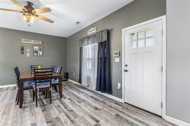 dining room with ceiling fan, visible vents, baseboards, and wood finished floors