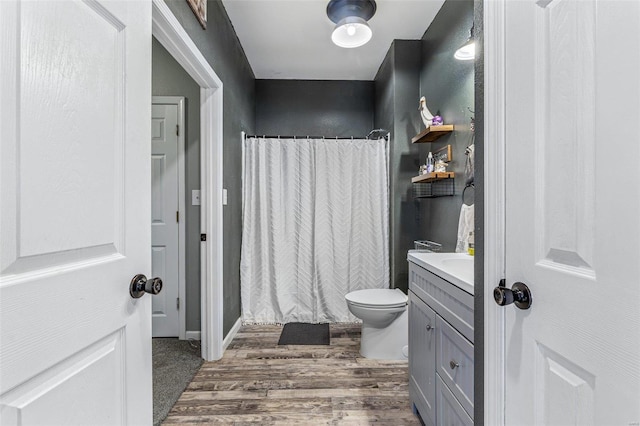 full bathroom featuring curtained shower, toilet, wood finished floors, and vanity