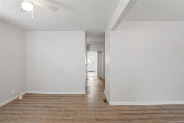 empty room with light wood-style flooring, visible vents, baseboards, and ceiling fan