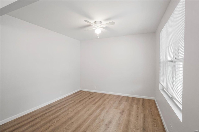 empty room with a ceiling fan, baseboards, and light wood finished floors