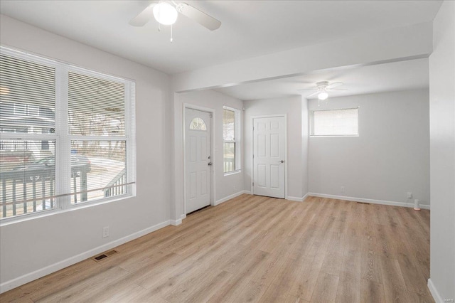 entryway featuring baseboards, visible vents, ceiling fan, and light wood finished floors