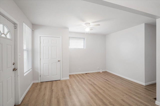 interior space with a ceiling fan, light wood-style flooring, and baseboards