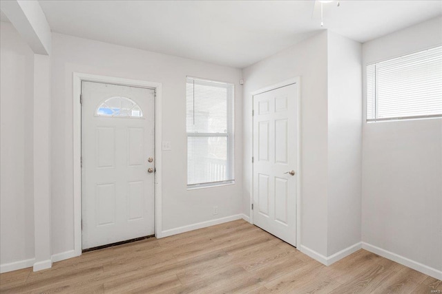 foyer entrance with light wood-type flooring and baseboards