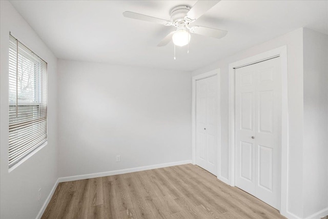 unfurnished bedroom featuring light wood-type flooring, a ceiling fan, and baseboards