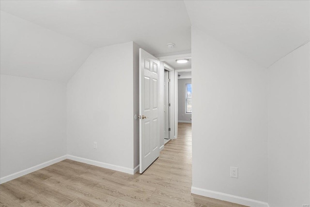 bonus room featuring vaulted ceiling, light wood-style flooring, and baseboards