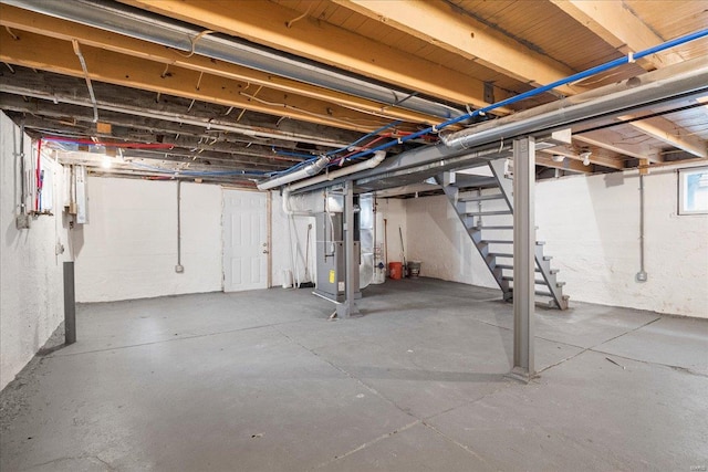 basement featuring stairway and heating unit