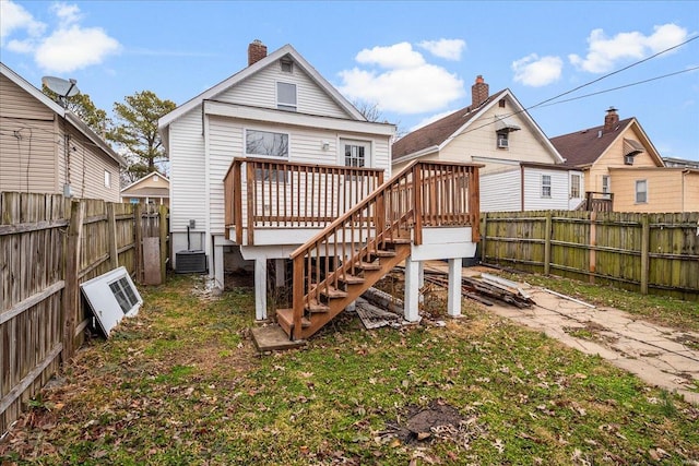 rear view of house with a deck, a fenced backyard, stairs, and central air condition unit