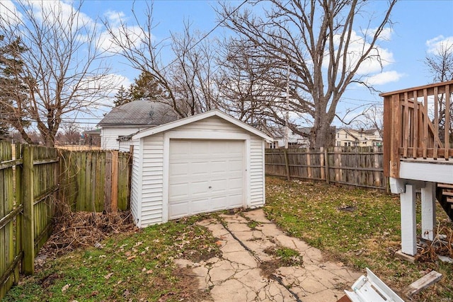 detached garage featuring fence and concrete driveway