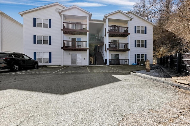 view of property featuring uncovered parking and fence