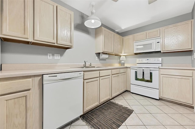kitchen featuring white appliances, light brown cabinets, and a sink