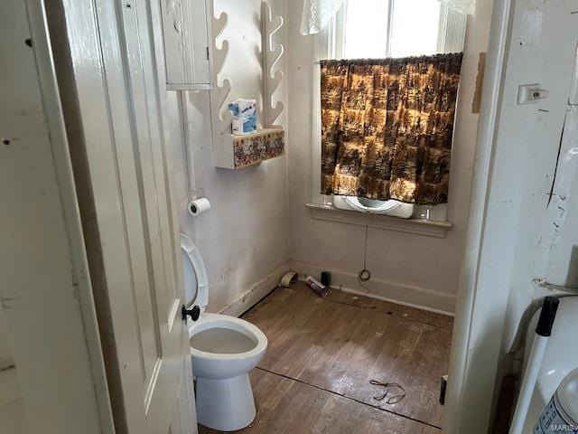 bathroom with wood finished floors, toilet, and baseboards