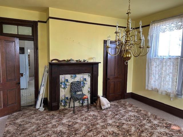 dining space with baseboards and a notable chandelier