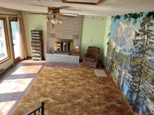 unfurnished living room with a fireplace, a textured ceiling, and ceiling fan