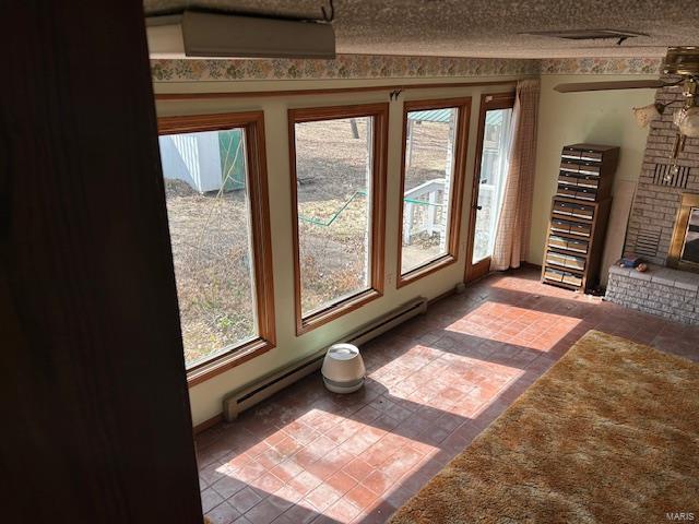 doorway to outside with a baseboard heating unit and a fireplace