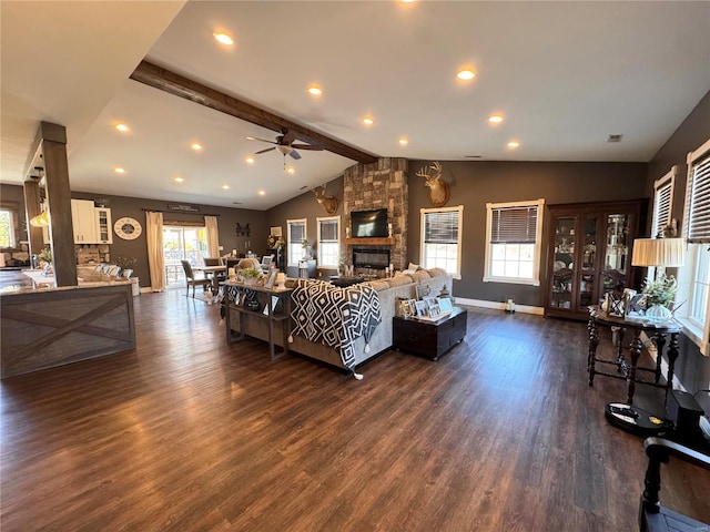 living area featuring baseboards, a ceiling fan, dark wood-style flooring, vaulted ceiling with beams, and a fireplace