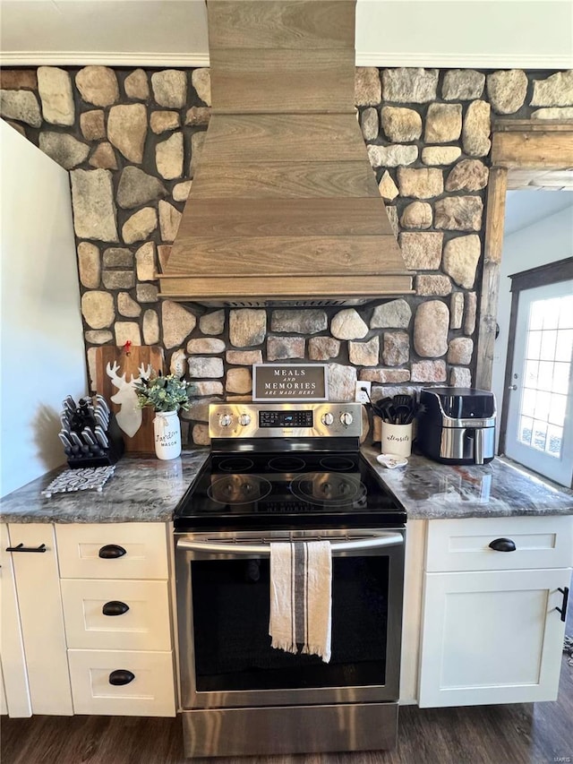 kitchen featuring white cabinets, custom range hood, dark stone countertops, dark wood-type flooring, and stainless steel electric stove