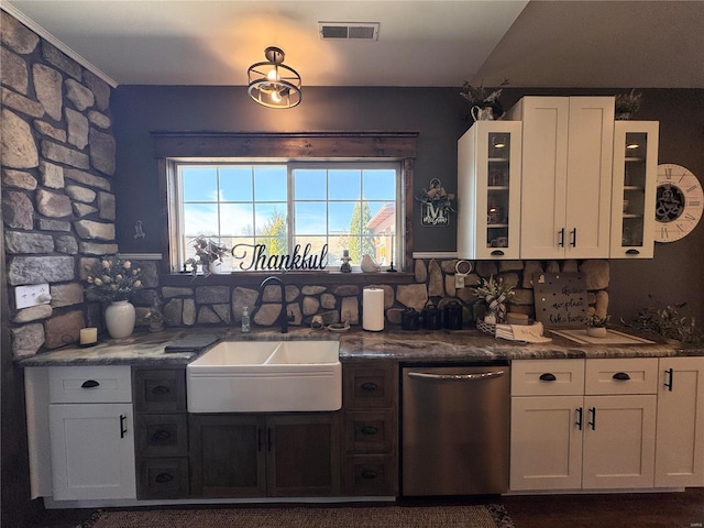 kitchen featuring a sink, visible vents, white cabinets, stainless steel dishwasher, and glass insert cabinets