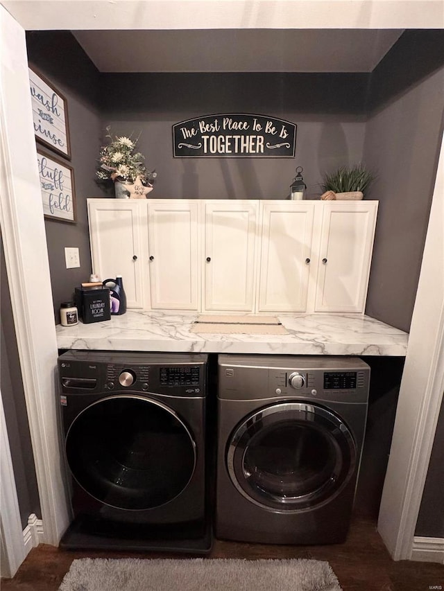 laundry room featuring washing machine and dryer and cabinet space