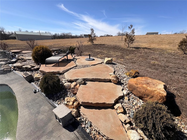 view of yard with a rural view and a patio