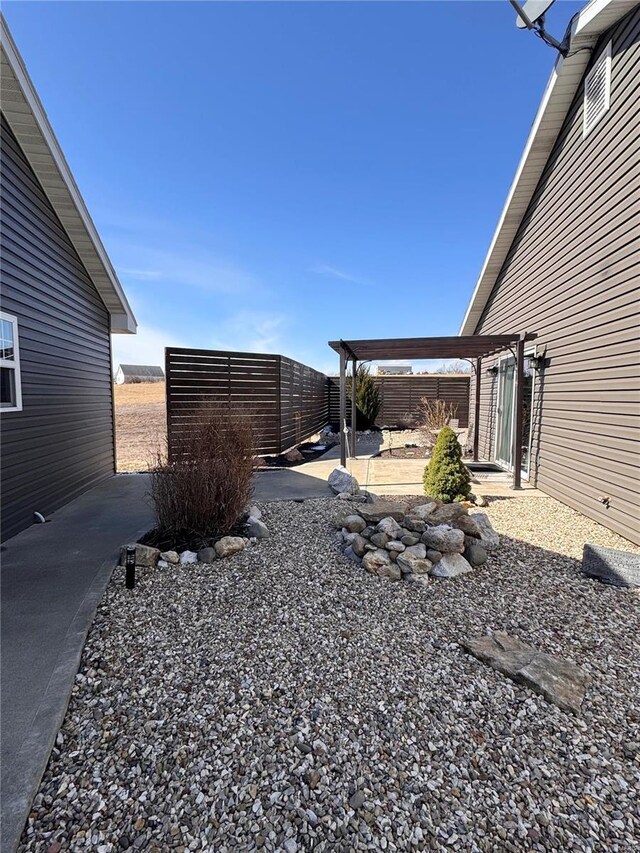 view of yard featuring a patio, fence, and a pergola