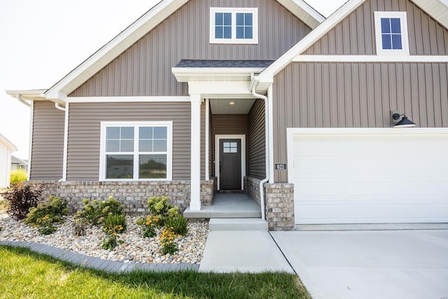 view of front of property with board and batten siding, stone siding, a shingled roof, and a garage