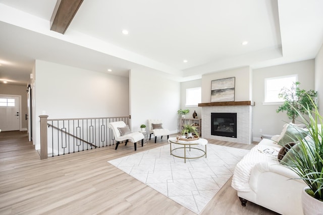 living area with recessed lighting, plenty of natural light, light wood-style flooring, and a raised ceiling