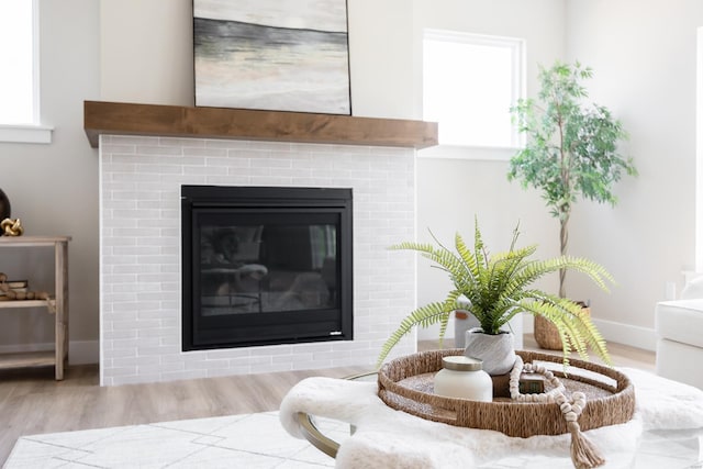 details with a brick fireplace, wood finished floors, and baseboards