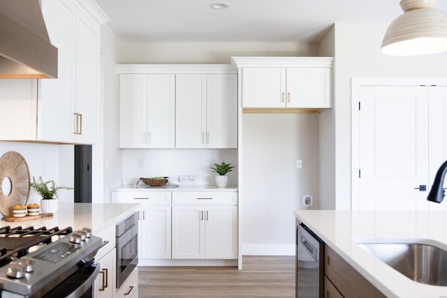 kitchen featuring wall chimney exhaust hood, built in microwave, stainless steel dishwasher, white cabinetry, and a sink