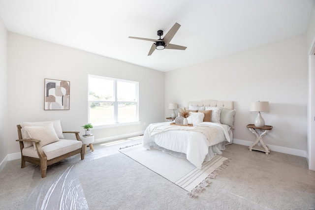 bedroom featuring ceiling fan, light carpet, and baseboards