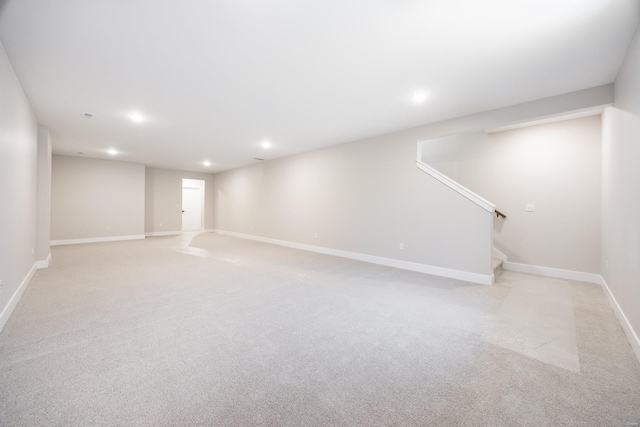 finished basement featuring stairs, baseboards, light colored carpet, and recessed lighting