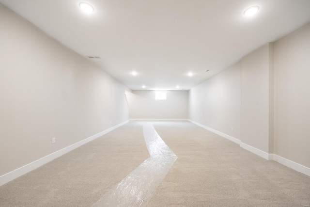 below grade area with light carpet, baseboards, visible vents, and recessed lighting