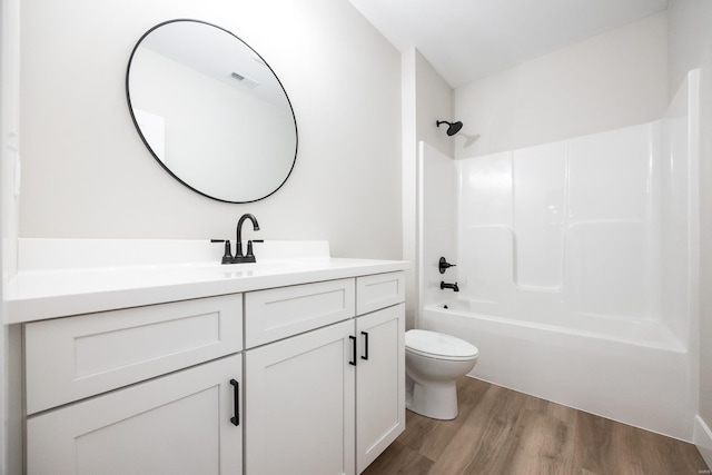 full bathroom featuring visible vents, toilet, wood finished floors, tub / shower combination, and vanity