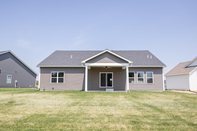 view of front of property featuring ceiling fan, a front lawn, and roof with shingles