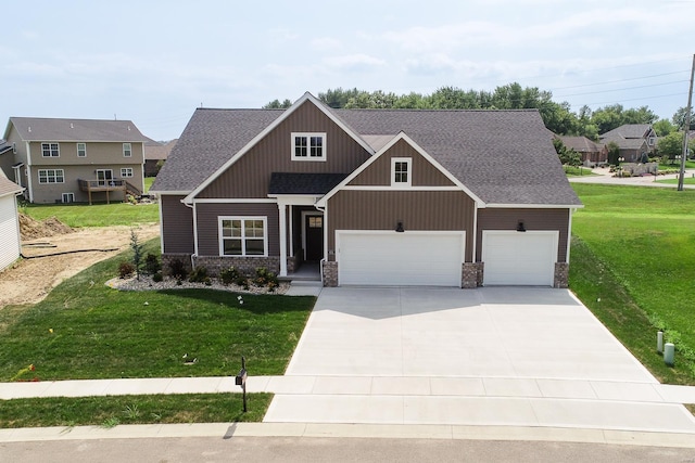 craftsman-style home with a garage, driveway, roof with shingles, and a front yard