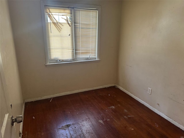 spare room featuring hardwood / wood-style flooring and baseboards