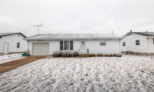 ranch-style house featuring an attached garage and central air condition unit