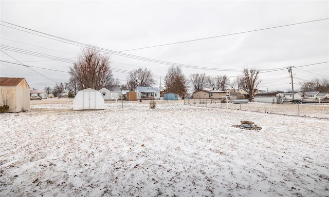 view of yard with a storage shed, an outdoor structure, fence, and a residential view